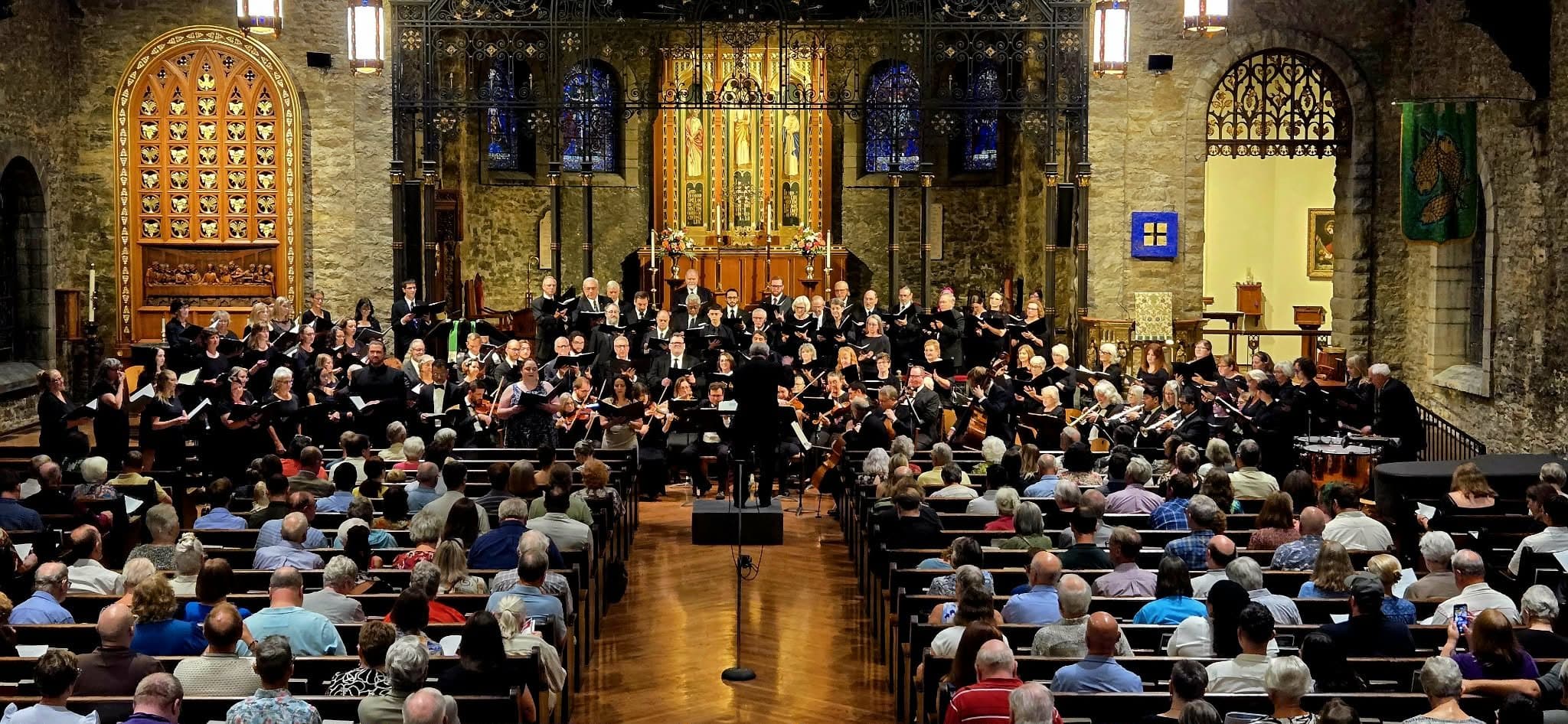 Choir and orchestra performing in a stone church