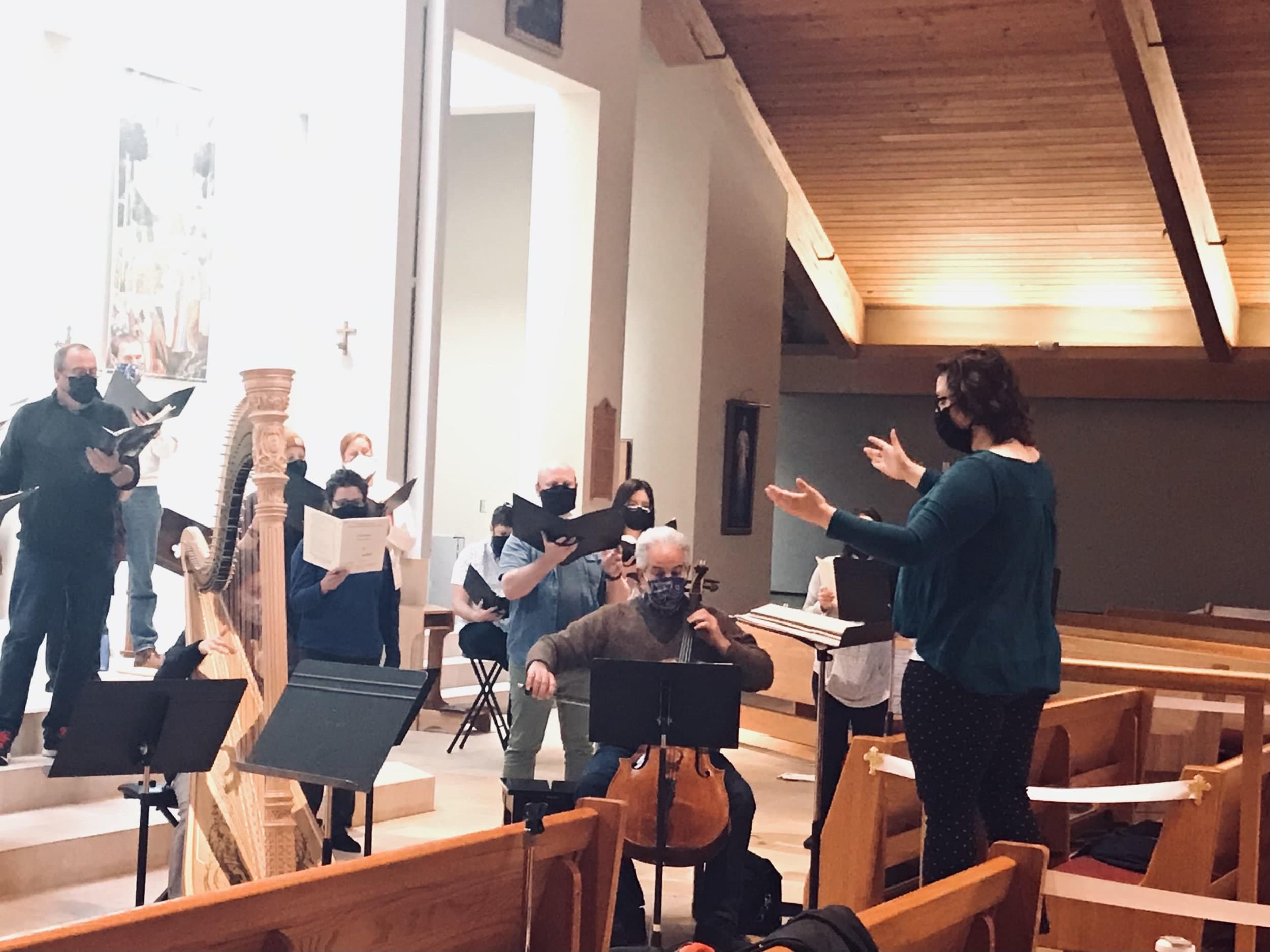 A Choral Intern conducting singers with cello and harp